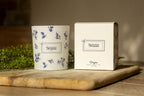 Origine candle in white glass with blue flowers